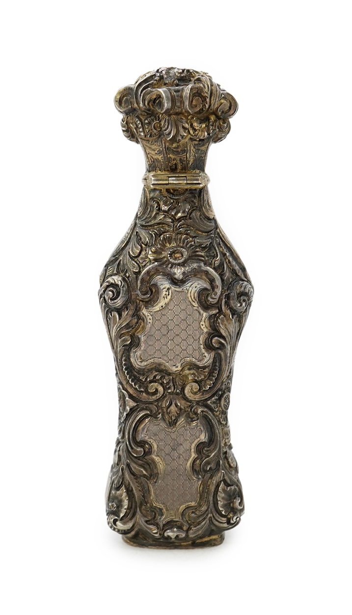 A 19th century French ornate parcel gilt white metal scent flask, with hinged cover and glass stopper
